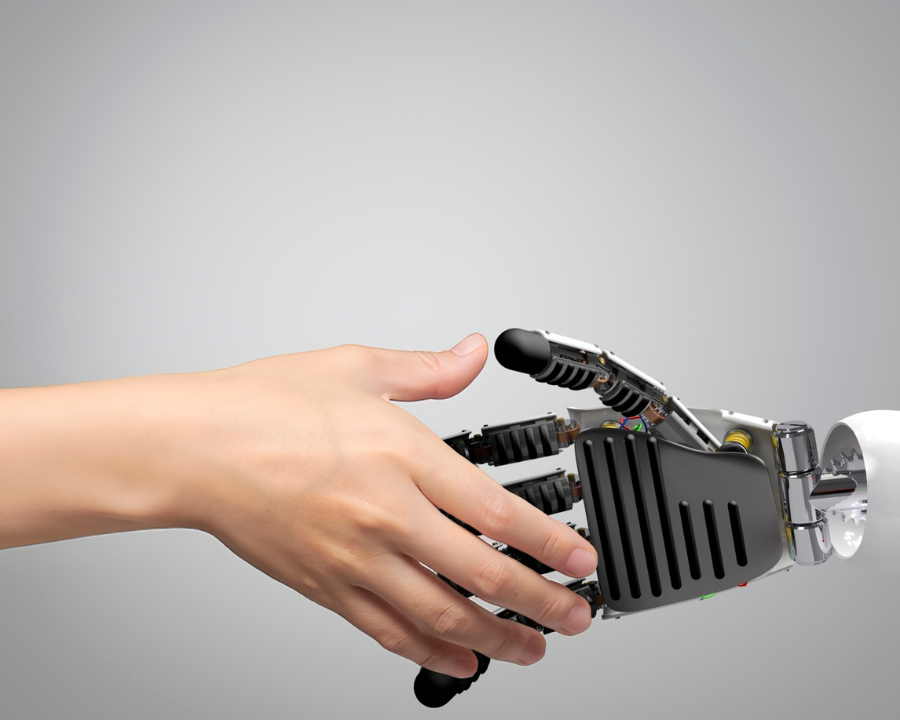 Menschliche Hand greift nach einer Roboterhand – symbolisiert Zusammenarbeit zwischen Mensch und künstlicher Intelligenz.